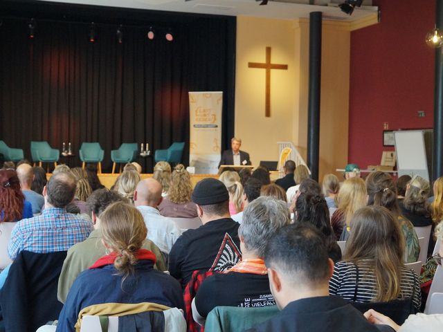 Das Publikum blickt Richtung Podium.