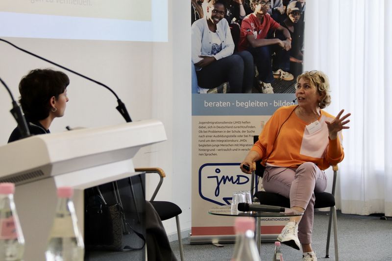 Zwei Menschen auf einem Podium im Gespräch.
