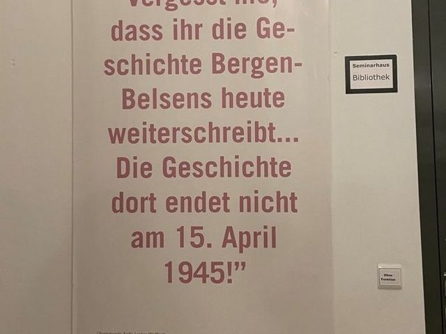Plakat mit dem Text "Vergesst nie, dass ihr die Geschichte Bergen-Belsens heute weiterschreibt. Die Geschichte dort endet nicht am 15. April 1945!"