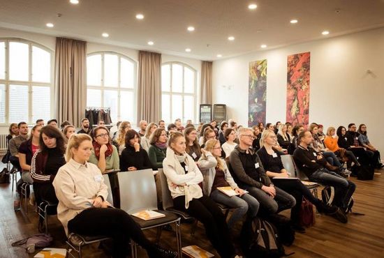 Mehrere Personen sitzen in einem Konferenzraum.