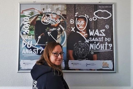 Junge Frau vor einem Plakat stehend.