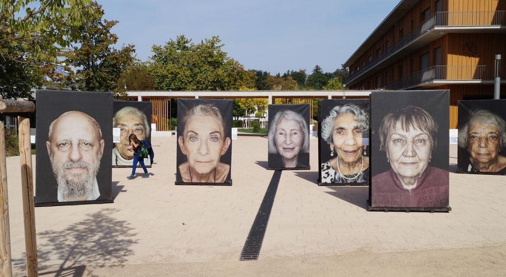 Große Porträts von Holocaust-Überlebenden sind auf einem Schulhof ausgestellt.
