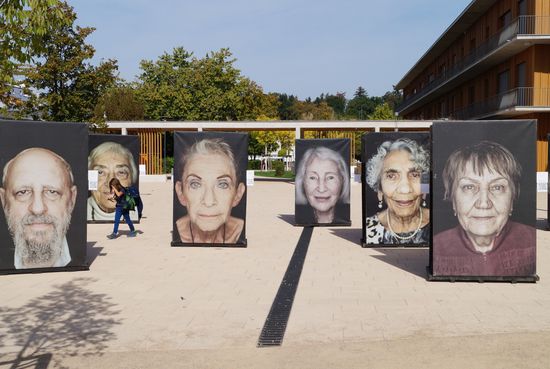 Große Porträts von Holocaust-Überlebenden sind auf einem Schulhof ausgestellt.