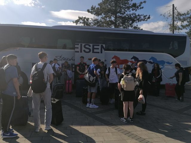 Eine Gruppe junger Menschen vor einem Reisebus.