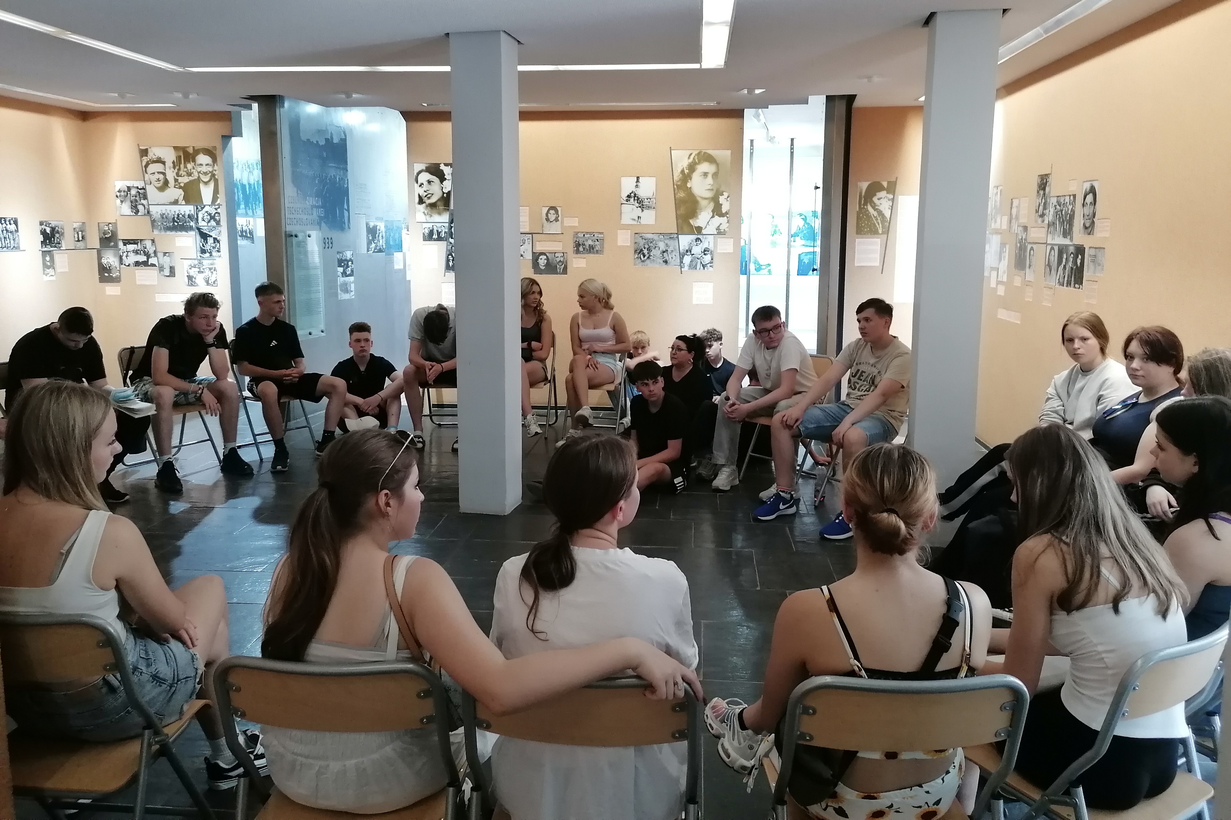 Eine Gruppe junger Menschen in einem Raum, sie sitzen im Stuhlkreis.